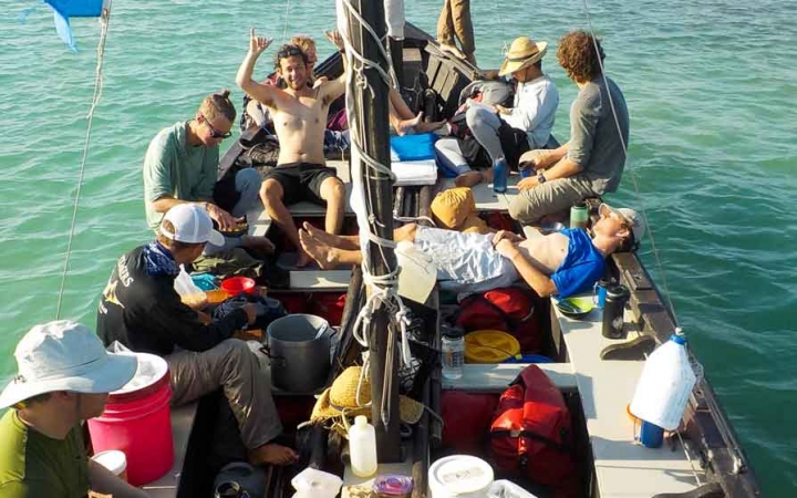 a group of students sit in a sailboat on an outward bound course in florida